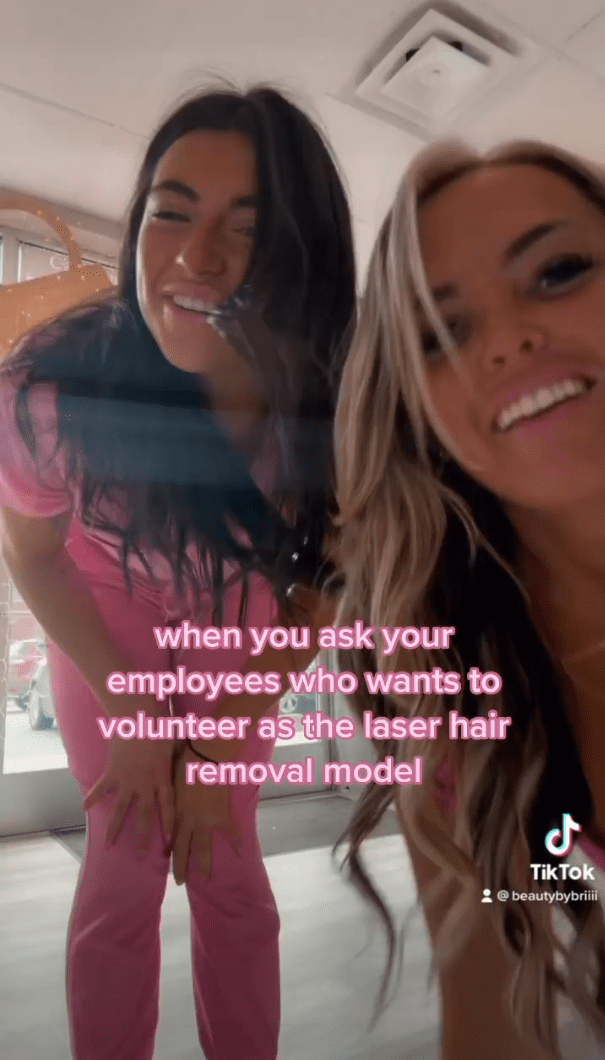 Two women are smiling while one of them is holding a hair removal device.